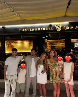 Family posing outside Hunter & Barrel restaurant.