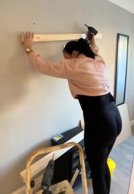 Woman installing a shelf.