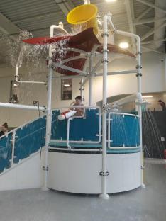Boy playing on water feature in a pool.