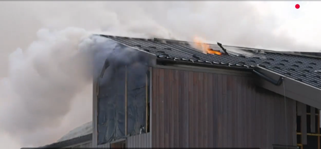 Building fire with smoke and flames.