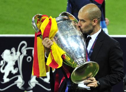 Pep Guardiola kissing the UEFA Champions League trophy.