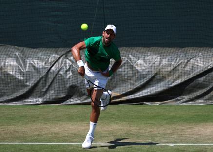 Novak Djokovic practicing on a tennis court.