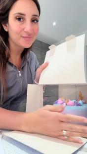 Woman revealing a decorated children's cake.