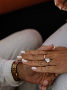 Close-up of hands showing an engagement ring.