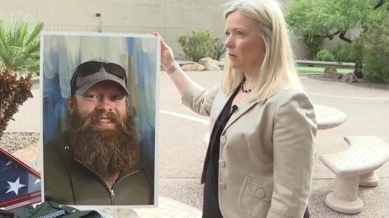 Woman holding a portrait of her deceased brother.