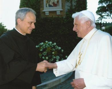 Pope Benedict XVI shaking hands with a priest.