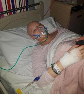 Megan Kelly, 19, in a hospital bed with an oxygen mask.