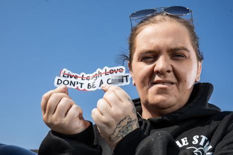 Woman holding a sticker that says