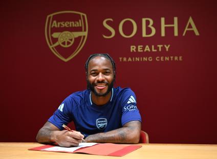 Raheem Sterling signing his Arsenal contract.