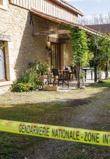 Police tape at a crime scene in front of a house.
