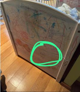 Child's crib with drawings, marked by investigators.