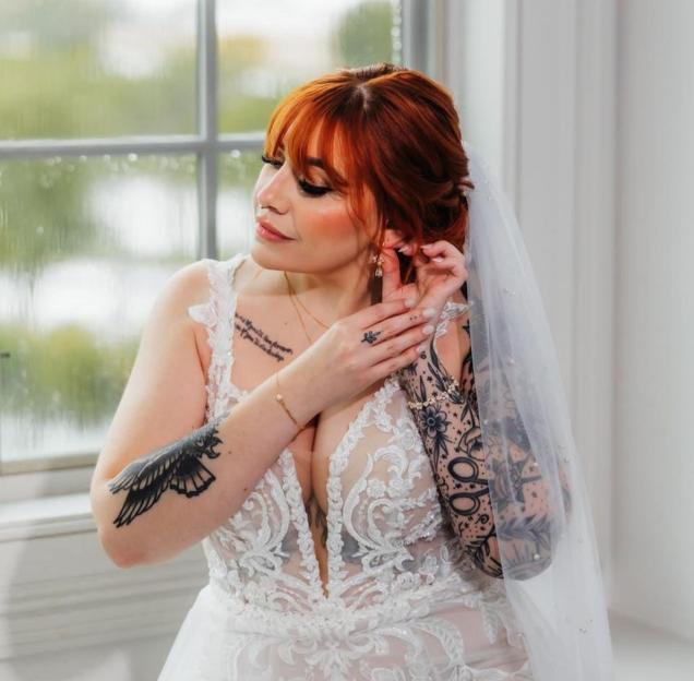 Bride adjusting her earrings on her wedding day.