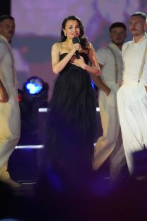 Samantha Barks speaking at a concert.