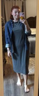 Woman taking a mirror selfie wearing a denim shirt over a midi dress.