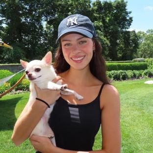 Woman holding a small white dog.