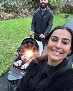 Family walking a baby in a stroller.