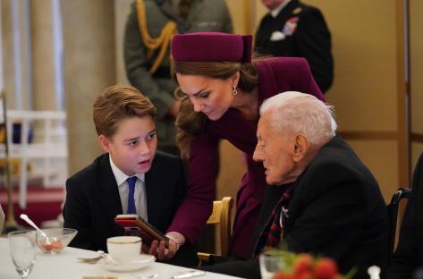 Prince George and Princess Catherine with a World War II veteran at a Buckingham Palace tea party.