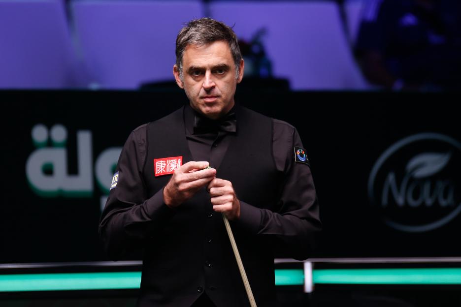 Ronnie O'Sullivan of England chalks his pool cue.