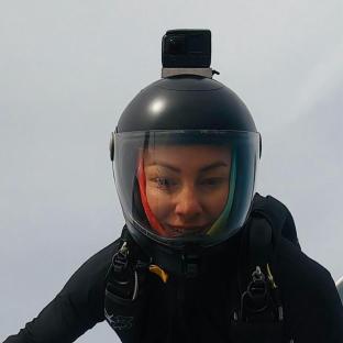 Person wearing a helmet with a camera mounted on top.
