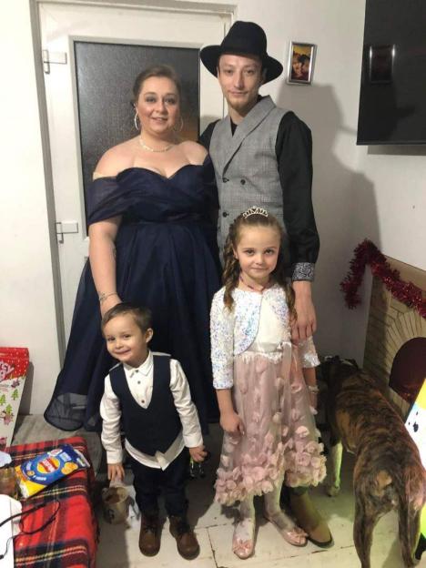 Photo of a family of four; a man and woman with two young children.