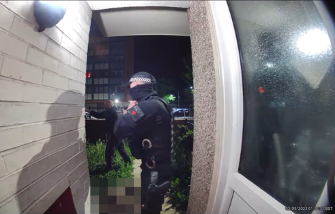 Doorbell camera footage of a police officer with two dogs.