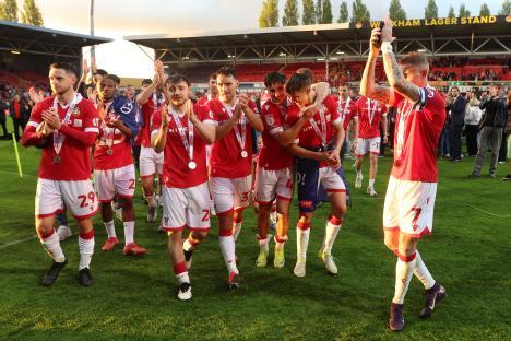 Wrexham AFC players celebrating promotion, wearing medals.