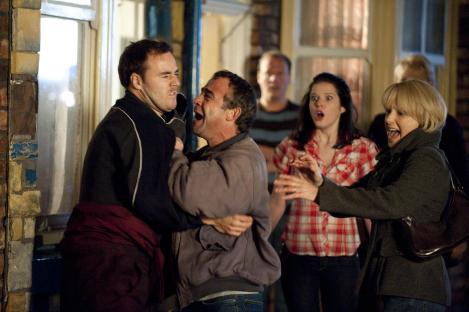 Scene from Coronation Street showing a fight between two men, with onlookers reacting.