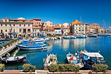 La Maddalena harbor in Sardinia, Italy, with boats and colorful buildings.