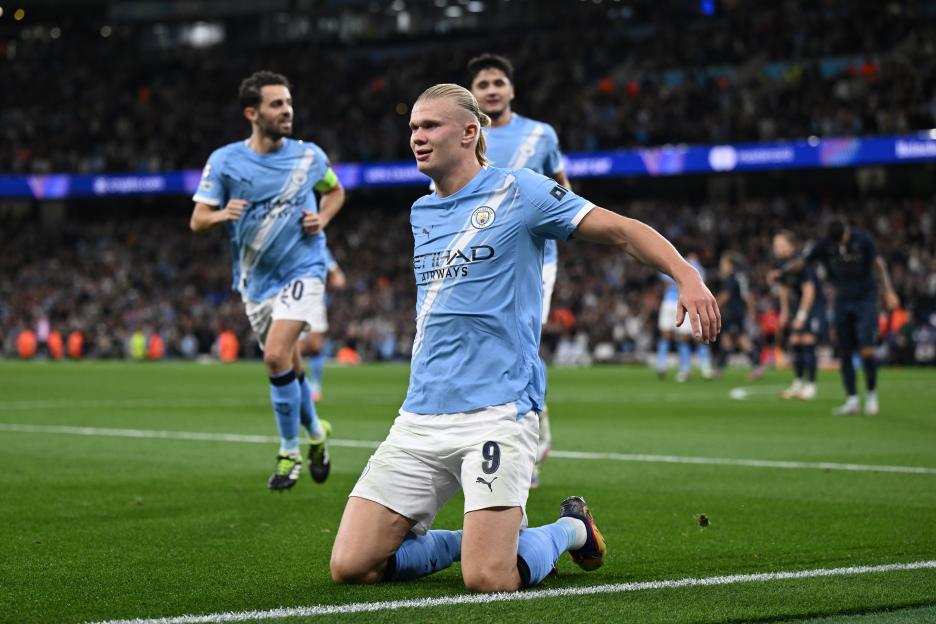 Erling Haaland of Manchester City celebrates his goal on one knee.