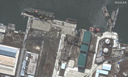Aerial view of a shipyard with several ships and buildings.