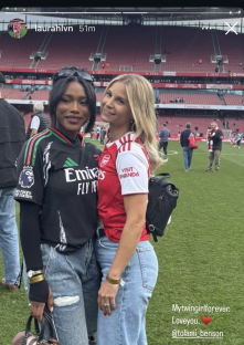 Two women in soccer jerseys at a stadium.