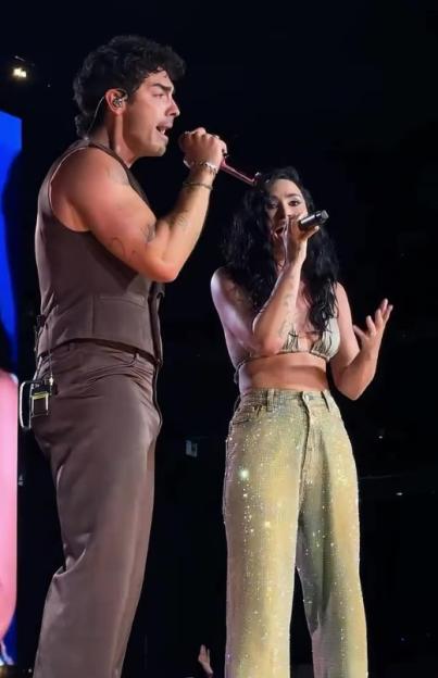 Demi Lovato and Joe Jonas singing on stage.