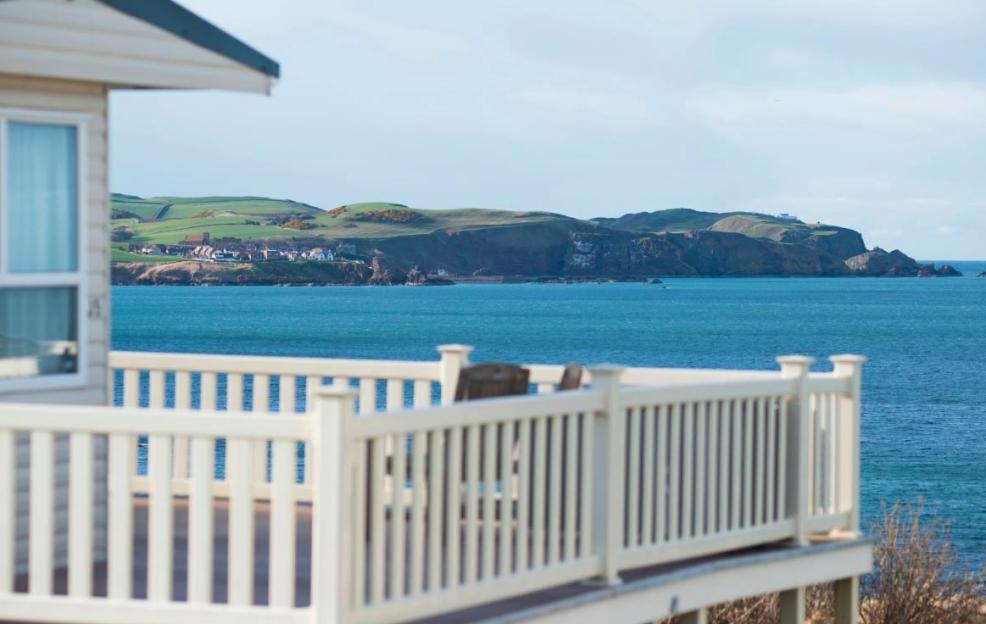 Ocean view from a deck with a white railing.