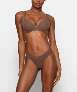 Model wearing a brown bra and thong.