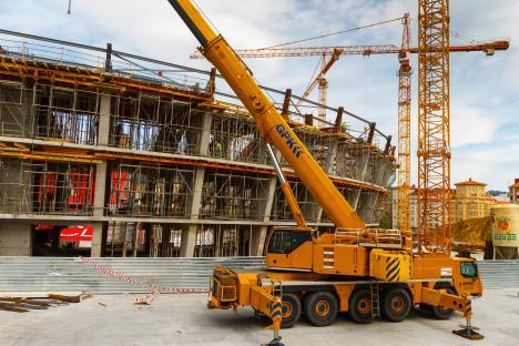 Construction site with cranes and a building under construction.