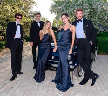 Family posing by a vintage car.