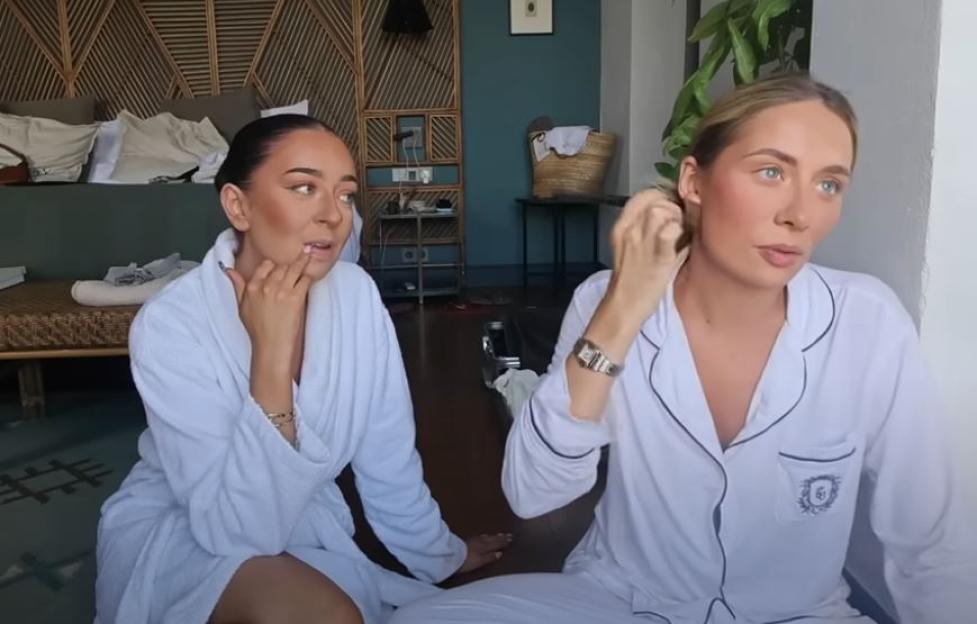 Two women wearing bathrobes and pajamas.