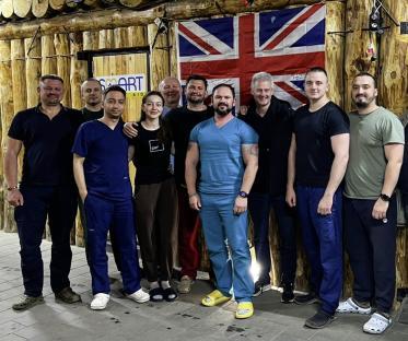 Group photo of medical personnel in front of a UK flag.