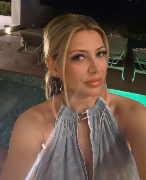 Selfie of Jasveen Sangha by a pool at night.