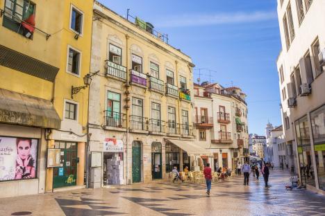 Lisbon street scene with tiled pedestrian area and buildings.