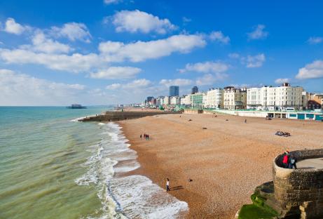 Brighton beach with people and buildings in the background.