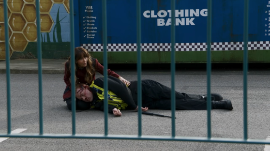 Woman kneeling over an injured police officer.