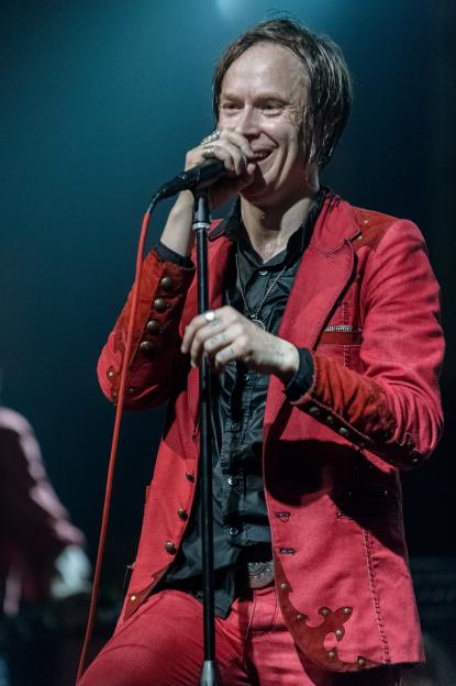 Dennis Lyxzen performing on stage.