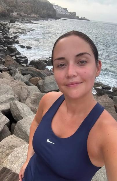 Woman in workout clothes by the sea.