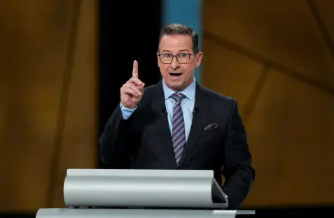 Man in suit giving a presentation.