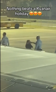 A woman being escorted off a Ryanair flight by airport security.