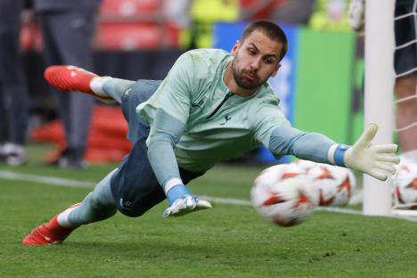 Soccer goalkeeper diving to catch the ball.