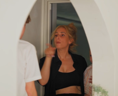 Screenshot of a woman gesturing to a man.