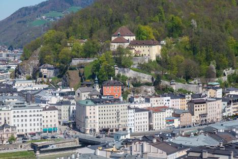 Aerial view of Salzburg, Austria, showing the Salzach River, historic architecture, and the Kapuzinerberg hill.
