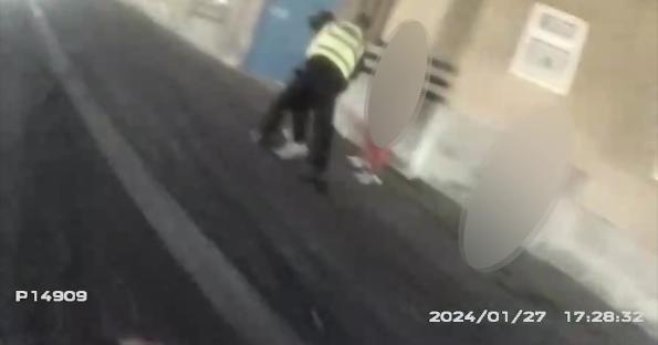 Video still of a police officer making an arrest.